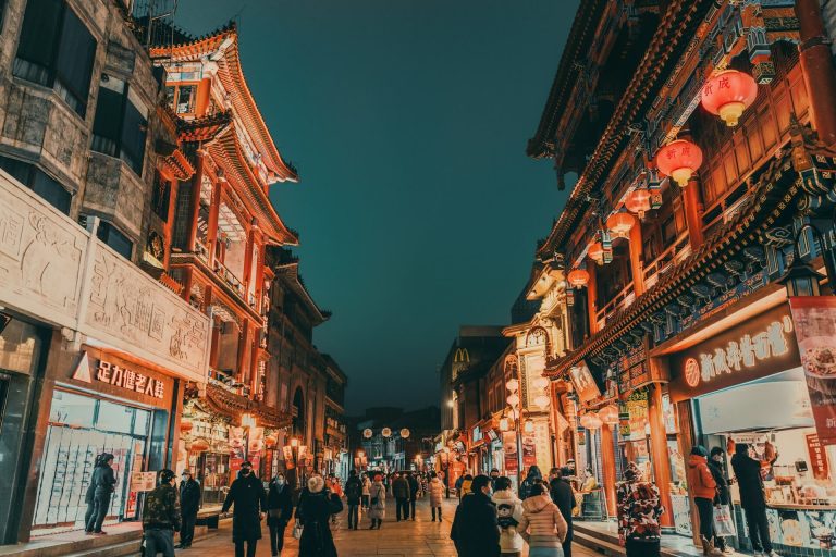 At night, many tourists in Beijing explore Qianmen Street and enjoy Beijing cuisine.