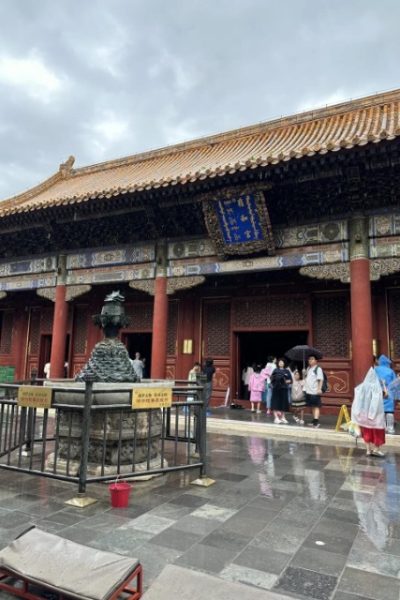 Hall-Lama Temple-Beijing Tourists taking shelter from the rain under the eaves of Yonghe Temple.