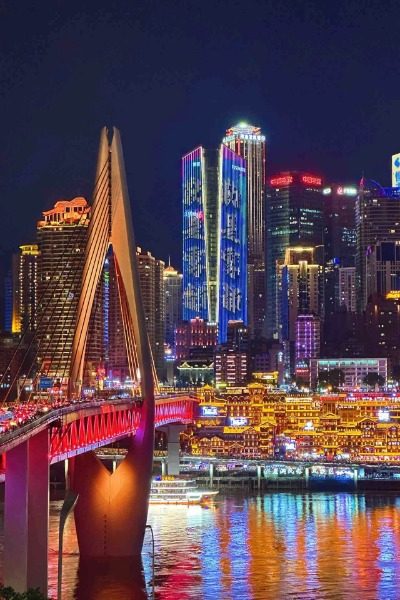 Night View-Hongya Cave-Chongqing The Qiansimen Bridge in Chongqing lights up with red lights, while the nearby Hongya Cave glows with golden yellow lights.