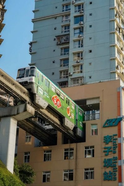 View 2-Liziba Station-Chongqing The subway train is emerging from within the residential buildings at Liziba Metro Station.