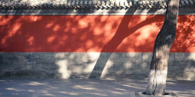 Wall-lama Temple-Beijing Sunlight shines on the traditional red walls lining the path.