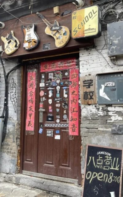 Wudaoying Hutong-Hutong Guide-Beijing A unique door in a Beijing hutong, with three guitars hanging on it.