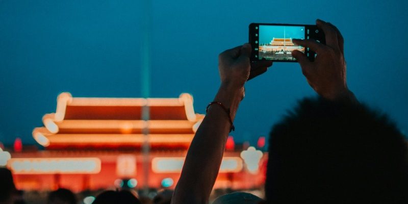flag-Tiananmen-Beijing Tourists traveling to Beijing raise their phones to capture the process of the flag-raising at dawn.