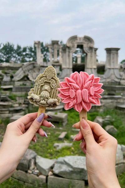 ice cream-Old Summer Palace-Beijing Tourists are holding up ice cream shaped like the Dashuifa for a photo.